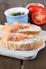 Fish sandwiches on cutting board on wooden table