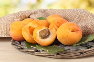 Apricots on wicker coasters on wooden table on nature