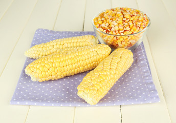 Fresh and dried corn on wooden background