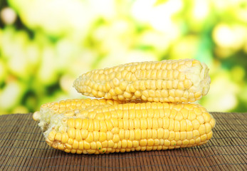 Fresh corn on bamboo mat, on bright background