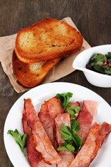 Bacon on plates on wooden table