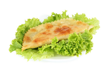Tasty cheburek with fresh herbs on plate, close-up