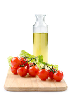 cherry tomatoes, lettuce and olive oil on a white background