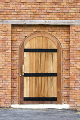 Wooden vintage closed door with brick wall to the house