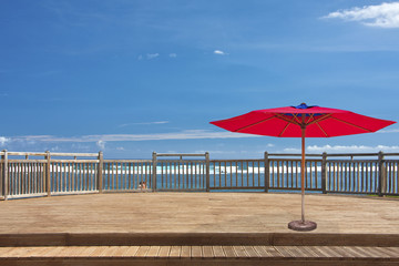 Fototapeta premium parasol rouge sur terrasse de bord de mer