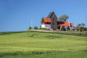 Fototapeta na wymiar Zielone pola i kościół Ruts Kirke