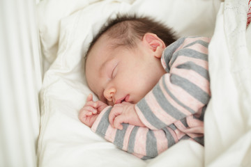 Small sleeping baby in bed (up to 20 days)