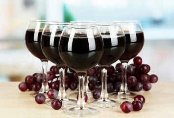 Red wine in glass on room background