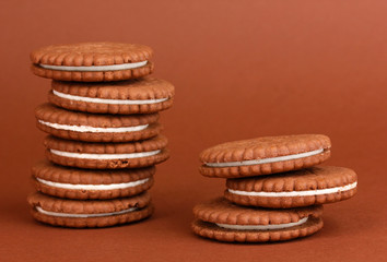 Chocolate cookies with creamy layer on brown background