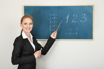 Portrait of teacher woman near chalkboard in classroom