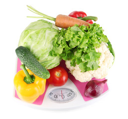 Fresh vegetables on scales on grey background
