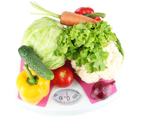 Fresh vegetables on scales on grey background