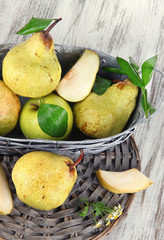 Pears in basket on braided tray on wooden table