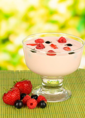 Delicious yogurt with fruit on table on bright background