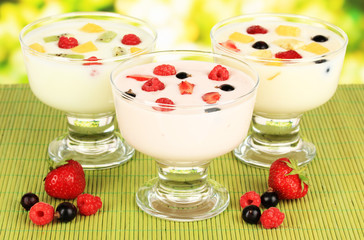 Delicious yogurt with fruit on table on bright background