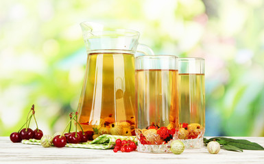 Pitcher and glasses of compote with summer berries