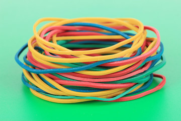 Colorful rubber bands on green background