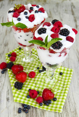 Natural yogurt with fresh berries on wooden background