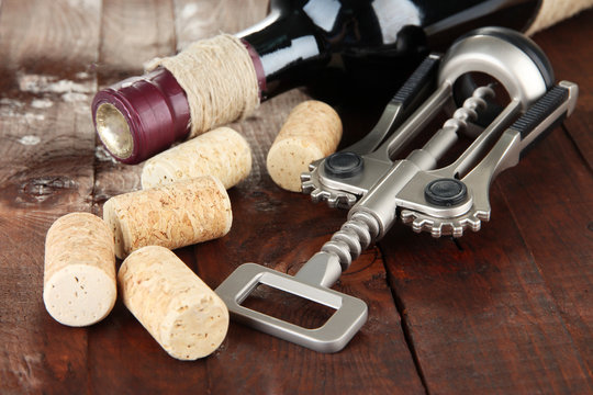 Corkscrew with wine corks and bottle of wine