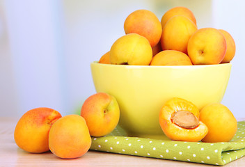Fresh natural apricot in bowl on table in kitchen