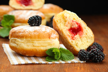 Tasty donuts with berries on wooden table