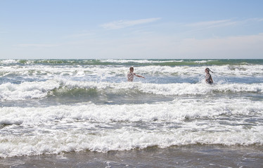 Boy and girl playing in the surf