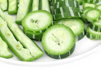 Chopped Snake gourd on a plate over white background