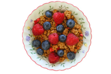 Breakfast cereal with fresh raspberries and blueberries on white