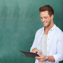 student mit tablet-computer vor der tafel