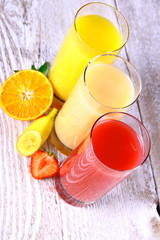 Oranges, bananas, strawberry slice and juice in glass