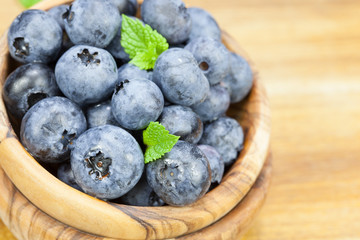 Blueberry.  Blueberries in olive wood bowl , close up .