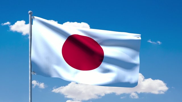 Japanese flag waving over a blue cloudy sky
