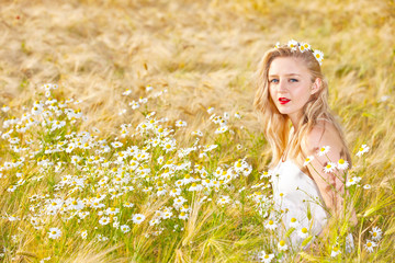 Blond girl on the camomile field