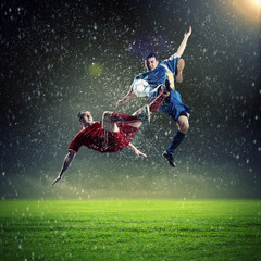 Fototapeta na wymiar two football players striking the ball