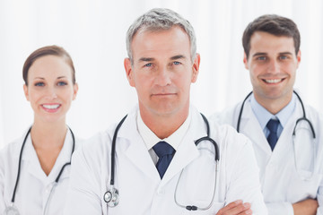 Fototapeta premium Cheerful doctors posing together crossing arms