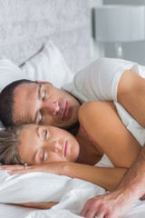Fototapeta na wymiar Cute couple sleeping and spooning in bed