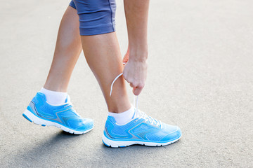 Closeup of Young Woman Tying Sports Shoe