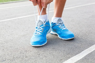 Closeup of Young Woman Tying Sports Shoe