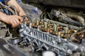 Hands of automechanic, who repairs car engine