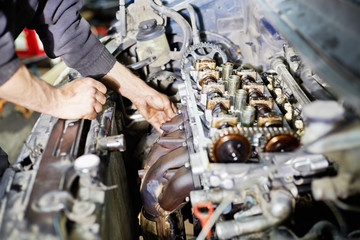Hands of mechanic servicing car engine