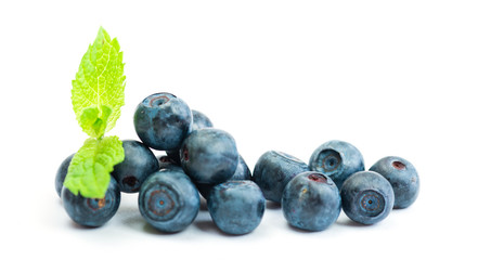 Fresh blueberry with green leaves of mint on white background