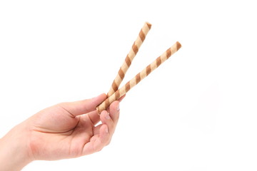 Hand holds striped chocolate wafer rolls