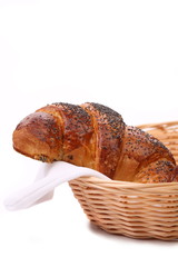 Appetizing croissants with poppy in basket.