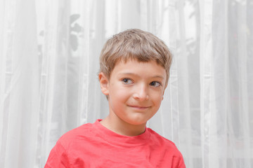 Smiling happy boy in red T-Shirt shot indoors