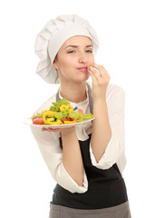 Pretty cook chief holding salad, isolated on white background