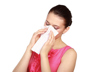 A portrait of a young woman blowing her nose