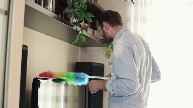Happy man cleaning tv and showing ok sign