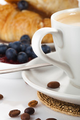coffee with croissants and blueberries on white background