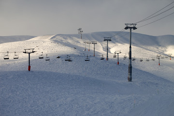 Fototapeta na wymiar Stok narciarski z wyciągiem krzesełkowym w godzinach wieczornych