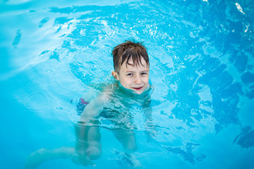 Fototapeta na wymiar Little happy boy in pool